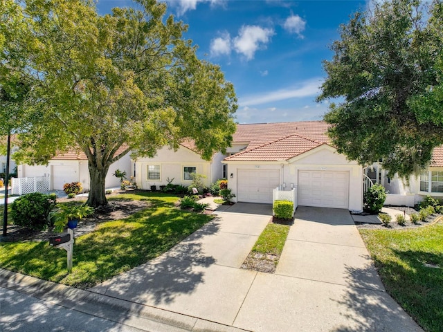 7518 Mediterranean Ct, Hudson, FL 34667 - view of front of house with a garage, driveway, stucco siding, a tile roof, and a front lawn