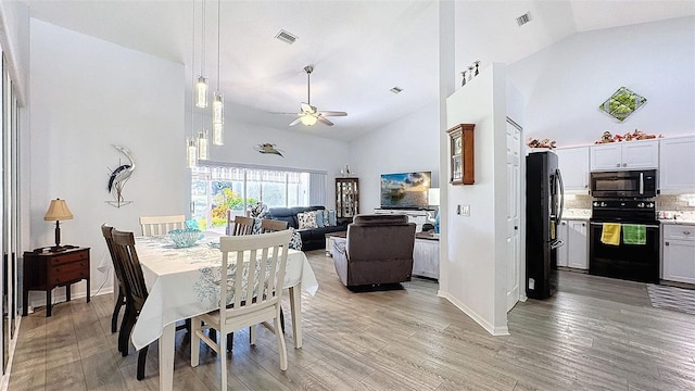 7518 Mediterranean Ct, Hudson, FL 34667 - dining area with ceiling fan, high vaulted ceiling, and light wood-type flooring