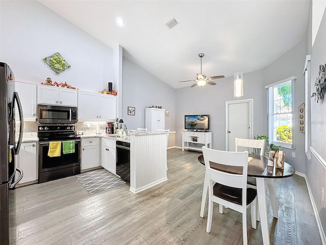 7518 Mediterranean Ct, Hudson, FL 34667 - kitchen with black appliances, a peninsula, light wood-style floors, high vaulted ceiling, and a ceiling fan