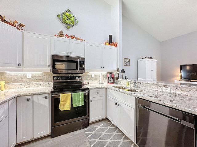 7518 Mediterranean Ct, Hudson, FL 34667 - kitchen featuring appliances with stainless steel finishes, decorative backsplash, white cabinetry, and high vaulted ceiling