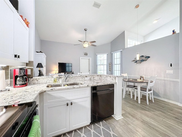7518 Mediterranean Ct, Hudson, FL 34667 - kitchen featuring dishwashing machine, a peninsula, ceiling fan, light wood-type flooring, and white cabinetry