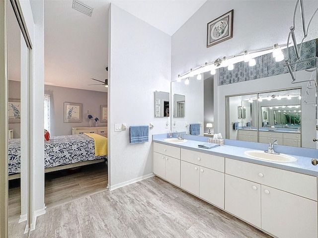 7518 Mediterranean Ct, Hudson, FL 34667 - full bathroom with ensuite bath, wood finished floors, double vanity, vaulted ceiling, and a ceiling fan