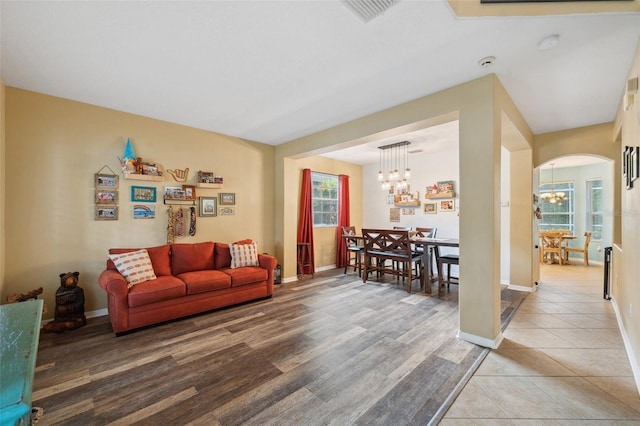 1410 Halapa Way, Trinity, FL 34655 - living room featuring a chandelier, arched walkways, and light tile patterned flooring