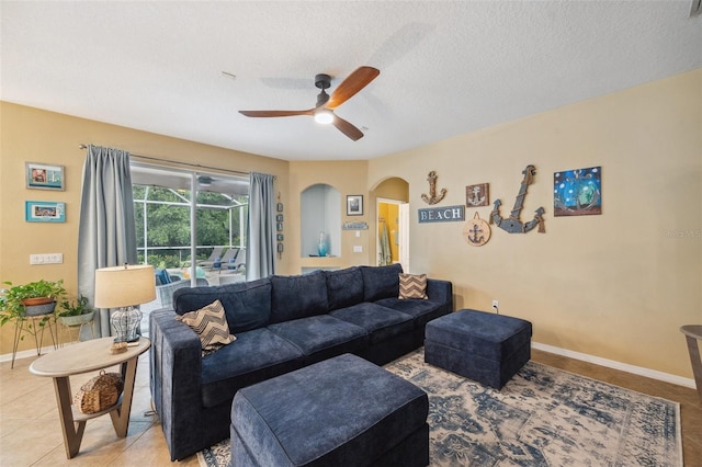 1410 Halapa Way, Trinity, FL 34655 - living area featuring arched walkways, a ceiling fan, light tile patterned floors, and a textured ceiling