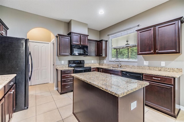 1104 Ketzal Dr, Trinity, FL 34655 - kitchen with black appliances, light tile patterned floors, arched walkways, and light stone counters