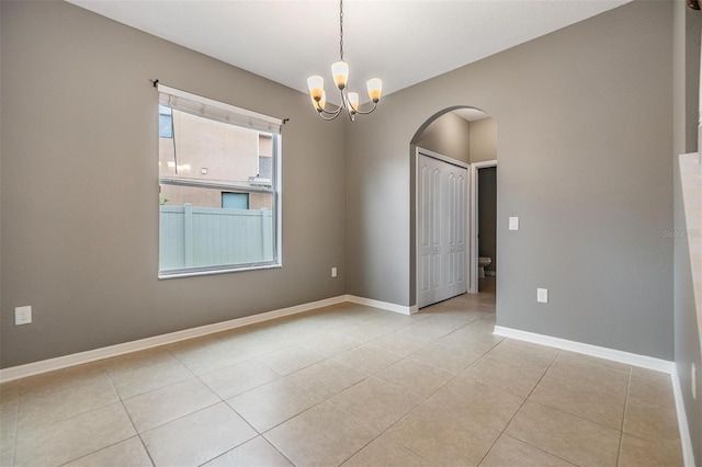 1104 Ketzal Dr, Trinity, FL 34655 - empty room with arched walkways, light tile patterned floors, and a chandelier
