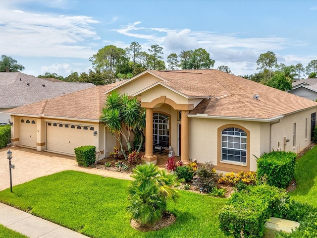 11144 Brambleleaf Way, Hudson, FL 34667 - view of front facade with stucco siding, a front lawn, roof with shingles, a garage, and driveway