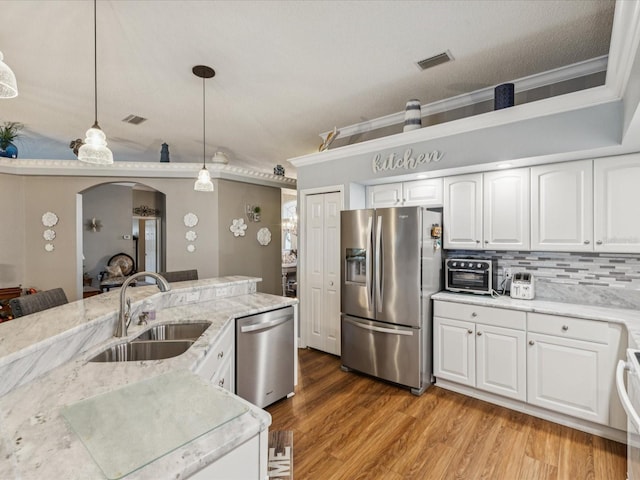 11144 Brambleleaf Way, Hudson, FL 34667 - kitchen with appliances with stainless steel finishes, pendant lighting, light wood finished floors, decorative backsplash, and light stone countertops