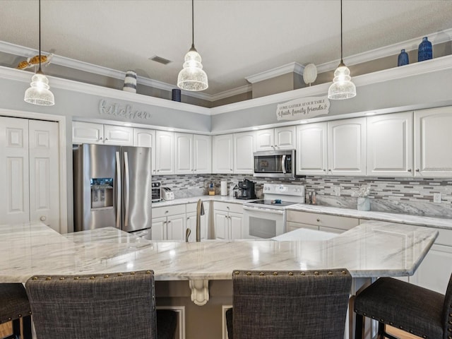 11144 Brambleleaf Way, Hudson, FL 34667 - kitchen featuring appliances with stainless steel finishes, a breakfast bar, hanging light fixtures, and ornamental molding