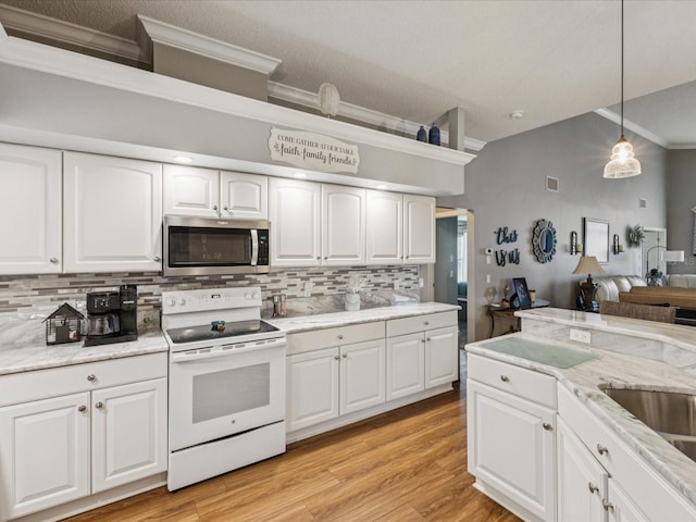 11144 Brambleleaf Way, Hudson, FL 34667 - kitchen featuring white electric stove, stainless steel microwave, crown molding, tasteful backsplash, and pendant lighting