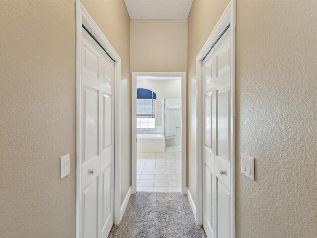 11144 Brambleleaf Way, Hudson, FL 34667 - hallway with a textured wall, carpet flooring, and tile patterned flooring