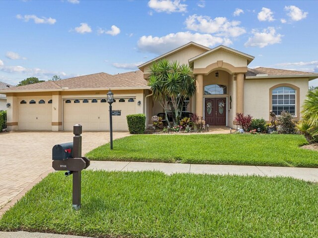11144 Brambleleaf Way, Hudson, FL 34667 - view of front facade featuring stucco siding, an attached garage, and driveway