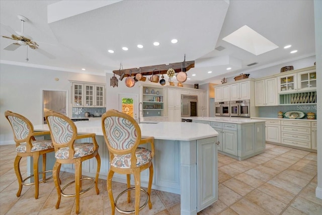 7275 Crystal Spring Run, Weeki Wachee, FL 34607 - kitchen featuring a large island, decorative backsplash, a skylight, stainless steel oven, and fridge