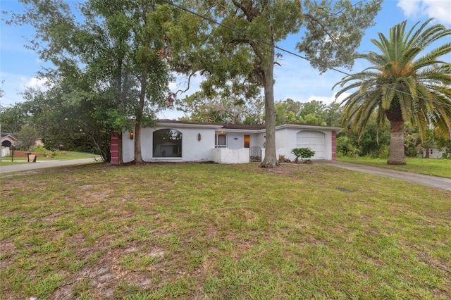 8340 Saint Marks Ct, Hudson, FL 34667 - ranch-style house featuring asphalt driveway, stucco siding, a front yard, and a garage