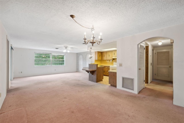 8340 Saint Marks Ct, Hudson, FL 34667 - unfurnished living room featuring arched walkways, light carpet, a ceiling fan, a chandelier, and a textured ceiling