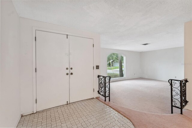8340 Saint Marks Ct, Hudson, FL 34667 - entryway featuring light carpet and a textured ceiling
