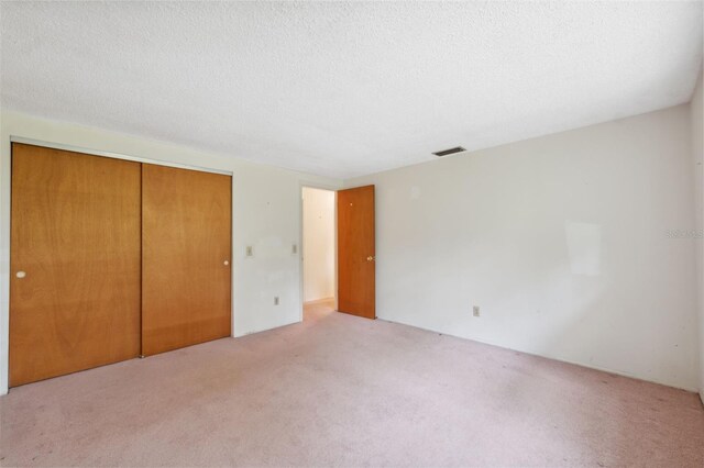 8340 Saint Marks Ct, Hudson, FL 34667 - unfurnished bedroom featuring carpet flooring, a closet, and a textured ceiling