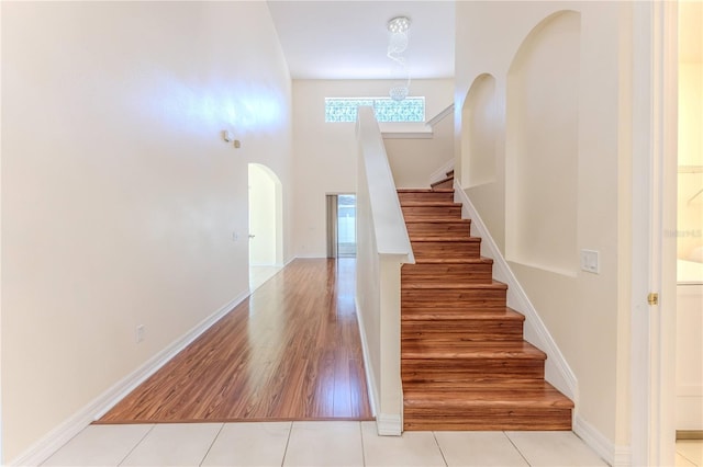 13772 Dunwoody Dr, Spring Hill, FL 34609 - staircase with arched walkways, wood finished floors, and a towering ceiling