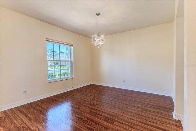 13772 Dunwoody Dr, Spring Hill, FL 34609 - spare room featuring dark wood finished floors and a chandelier