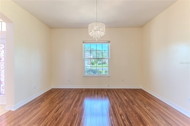 13772 Dunwoody Dr, Spring Hill, FL 34609 - unfurnished room featuring wood finished floors, arched walkways, and a chandelier