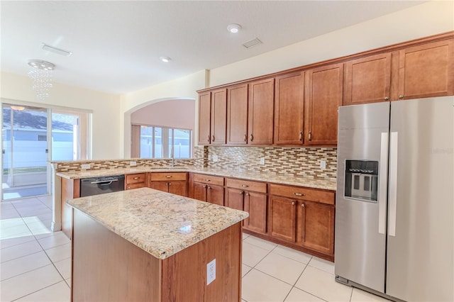 13772 Dunwoody Dr, Spring Hill, FL 34609 - kitchen featuring stainless steel fridge, dishwashing machine, brown cabinets, decorative backsplash, and light stone countertops