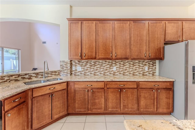 13772 Dunwoody Dr, Spring Hill, FL 34609 - kitchen with freestanding refrigerator, light stone counters, tasteful backsplash, and brown cabinets