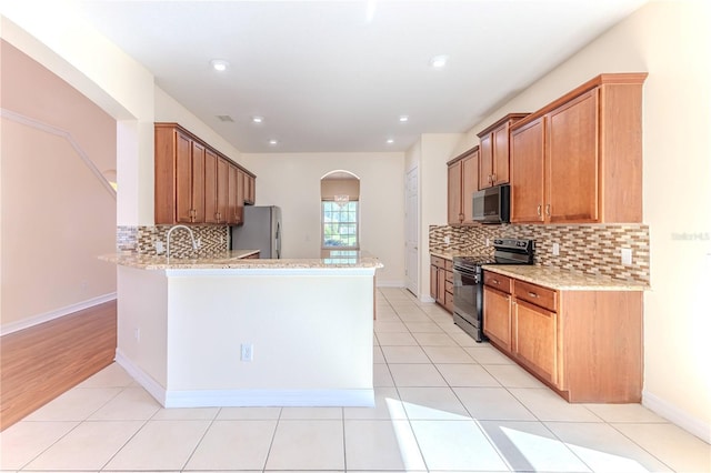 13772 Dunwoody Dr, Spring Hill, FL 34609 - kitchen with black / electric stove, freestanding refrigerator, arched walkways, backsplash, and recessed lighting