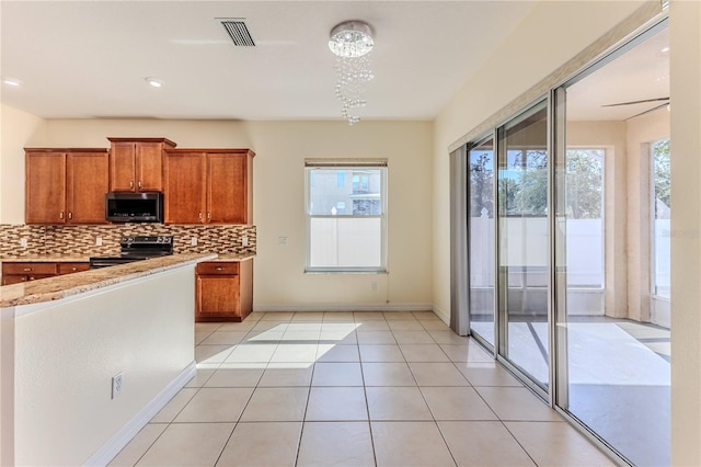 13772 Dunwoody Dr, Spring Hill, FL 34609 - kitchen featuring appliances with stainless steel finishes, tasteful backsplash, brown cabinets, light tile patterned floors, and recessed lighting
