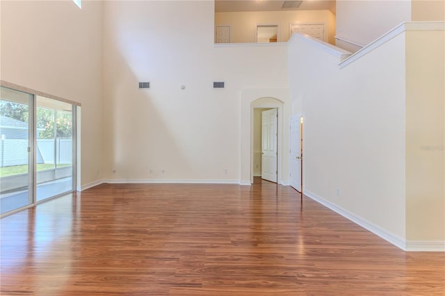 13772 Dunwoody Dr, Spring Hill, FL 34609 - unfurnished living room with a high ceiling, wood finished floors, and arched walkways