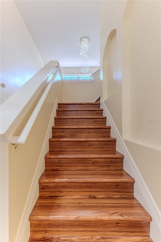 13772 Dunwoody Dr, Spring Hill, FL 34609 - stairway featuring a chandelier and arched walkways