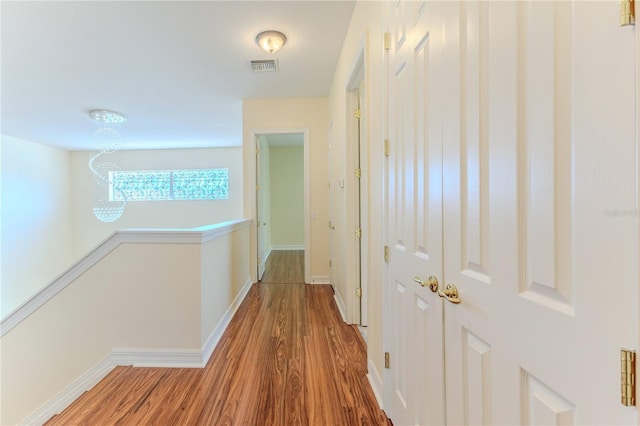 13772 Dunwoody Dr, Spring Hill, FL 34609 - hall featuring wood finished floors, a chandelier, and an upstairs landing