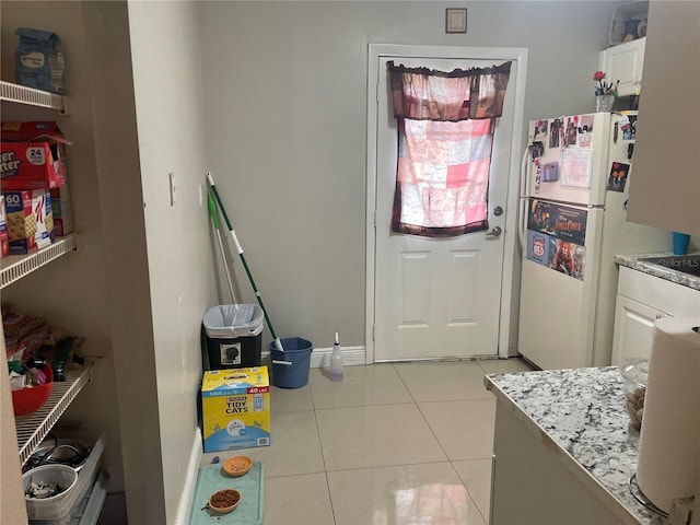 203 Pine Violet Ct Unit 202, Tampa, FL 33612 - kitchen featuring freestanding refrigerator, white cabinets, and light stone countertops