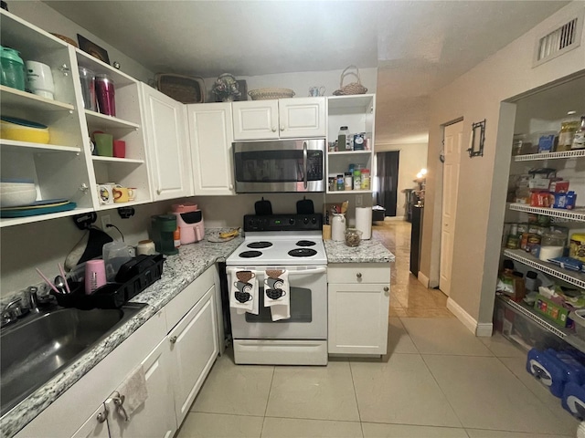 203 Pine Violet Ct Unit 202, Tampa, FL 33612 - kitchen featuring white electric stove, stainless steel microwave, open shelves, light tile patterned floors, and white cabinets