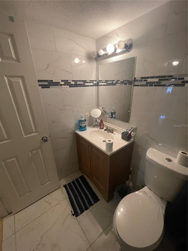 203 Pine Violet Ct Unit 202, Tampa, FL 33612 - half bathroom featuring marble look tile flooring, tile walls, vanity, and a textured ceiling