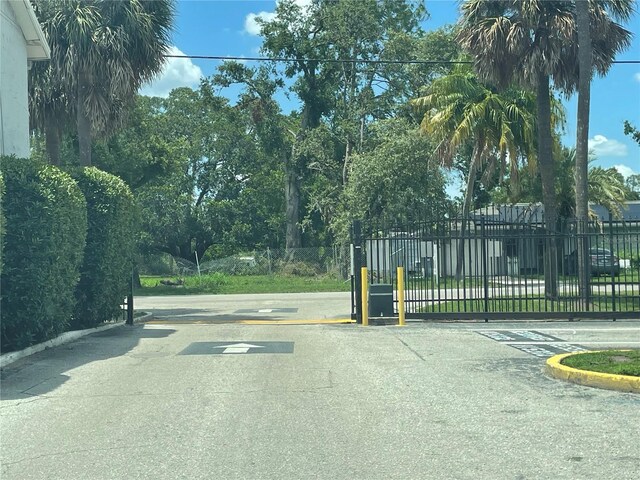 203 Pine Violet Ct Unit 202, Tampa, FL 33612 - view of asphalt street with curbs, a gated entry, and a gate
