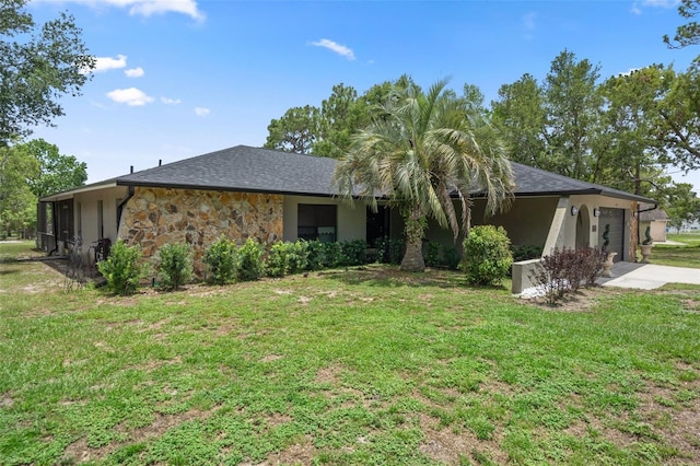 1376 Fayetteville Dr, Spring Hill, FL 34609 - back of house featuring an attached garage, a yard, stone siding, driveway, and stucco siding