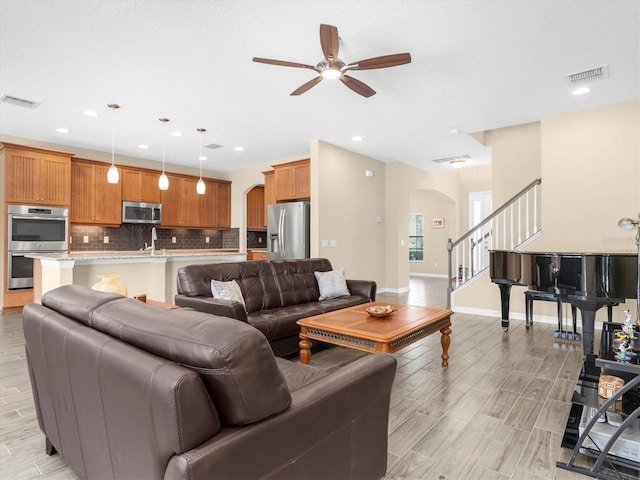 19326 Long Lake Ranch Blvd, Lutz, FL 33558 - living area featuring arched walkways, ceiling fan, stairway, recessed lighting, and light wood finished floors