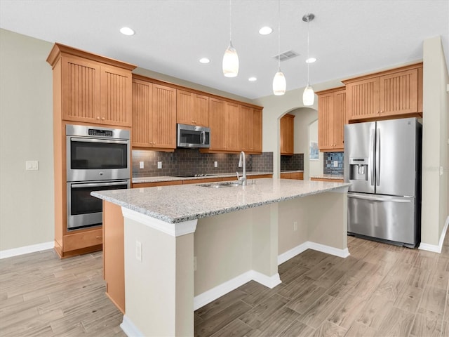 19326 Long Lake Ranch Blvd, Lutz, FL 33558 - kitchen featuring stainless steel appliances, decorative backsplash, arched walkways, light wood-style floors, and recessed lighting
