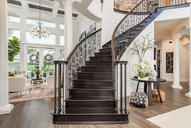 10342 Altrara Way, Trinity, FL 34655 - stairway featuring a towering ceiling, ornate columns, coffered ceiling, a chandelier, and beamed ceiling