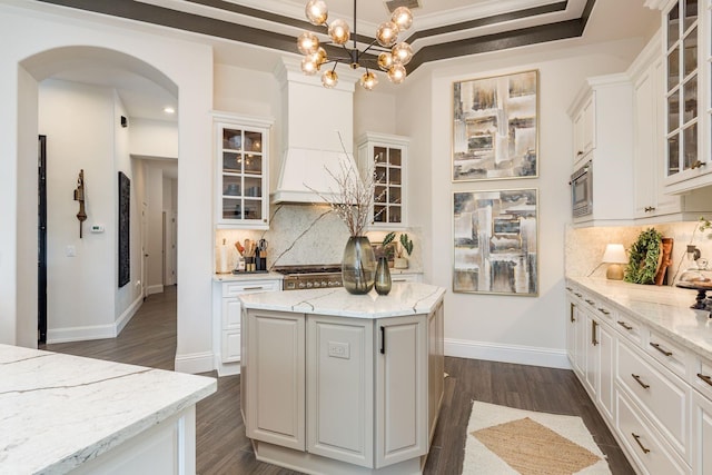 10342 Altrara Way, Trinity, FL 34655 - kitchen with arched walkways, white cabinets, decorative backsplash, light stone counters, and recessed lighting