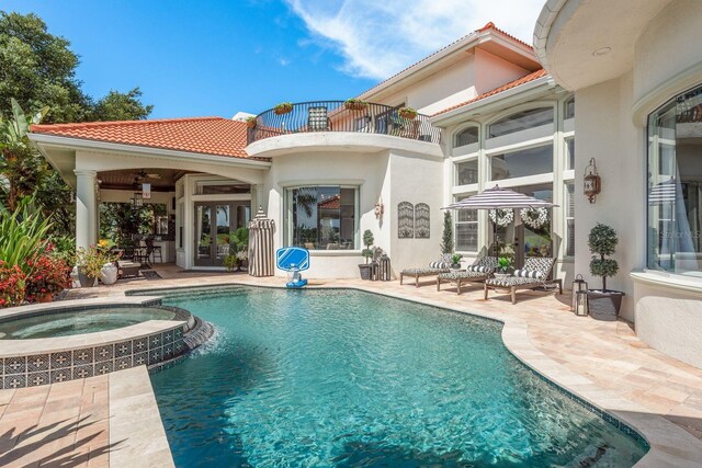 10342 Altrara Way, Trinity, FL 34655 - back of property with a balcony, french doors, a tiled roof, a patio, and stucco siding