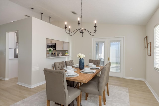 4752 Weasel Dr, New Port Richey, FL 34653 - dining room with lofted ceiling, a chandelier, light wood-style floors, and french doors