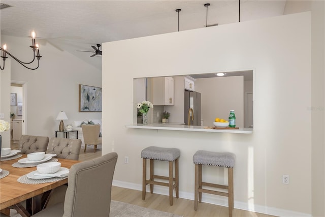 4752 Weasel Dr, New Port Richey, FL 34653 - dining area with light wood-style floors, vaulted ceiling, and a chandelier