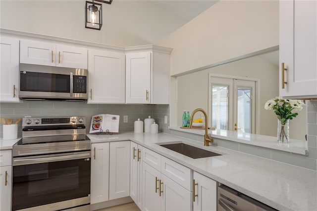 4752 Weasel Dr, New Port Richey, FL 34653 - kitchen featuring appliances with stainless steel finishes, backsplash, white cabinets, and light stone counters