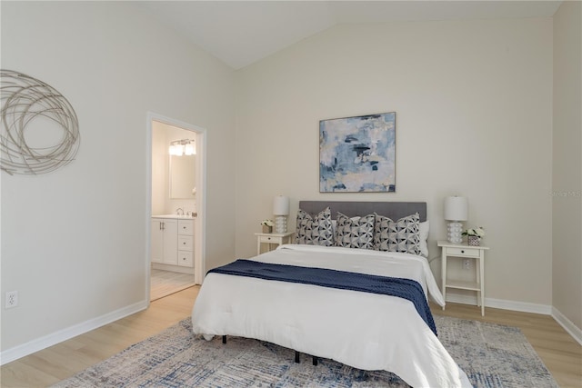 4752 Weasel Dr, New Port Richey, FL 34653 - bedroom featuring light wood finished floors, vaulted ceiling, and ensuite bath