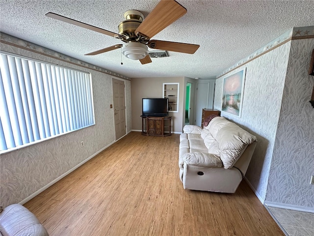 8312 Split Rail Ln, Hudson, FL 34667 - living room featuring wood finished floors, wallpapered walls, a textured ceiling, and a ceiling fan