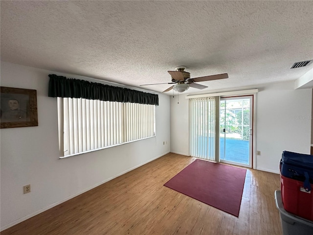 8312 Split Rail Ln, Hudson, FL 34667 - unfurnished living room with ceiling fan, wood finished floors, and a textured ceiling