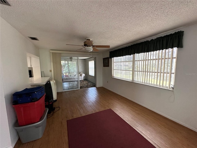 8312 Split Rail Ln, Hudson, FL 34667 - unfurnished living room with wood finished floors, a textured ceiling, and a ceiling fan