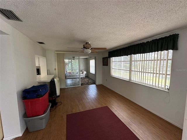 8312 Split Rail Ln, Hudson, FL 34667 - unfurnished living room featuring wood finished floors, a textured ceiling, and ceiling fan