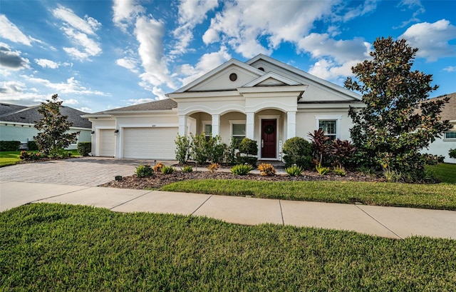 4197 Glade Wood Loop, New Port Richey, FL 34655 - greek revival inspired property with stucco siding, decorative driveway, an attached garage, a front yard, and covered porch